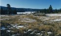 Snow Blown Field With Frozen Lake Behind