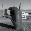 Bronze hand holding mailbox