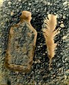 Bottle and Feather - Gravel Background