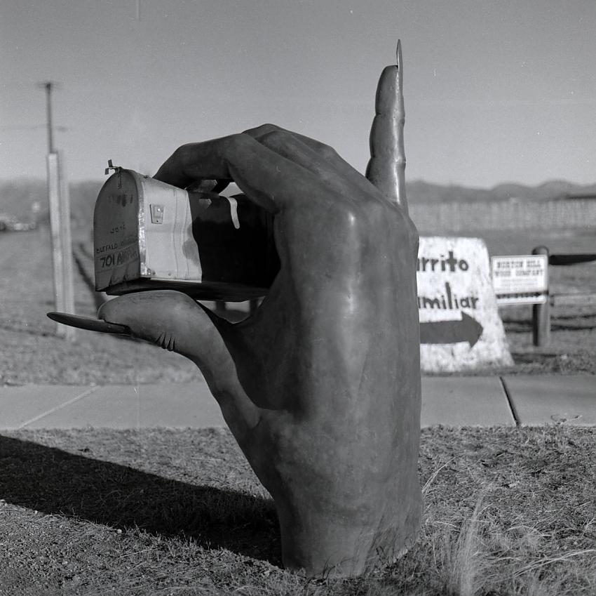 Bronze hand holding mailbox