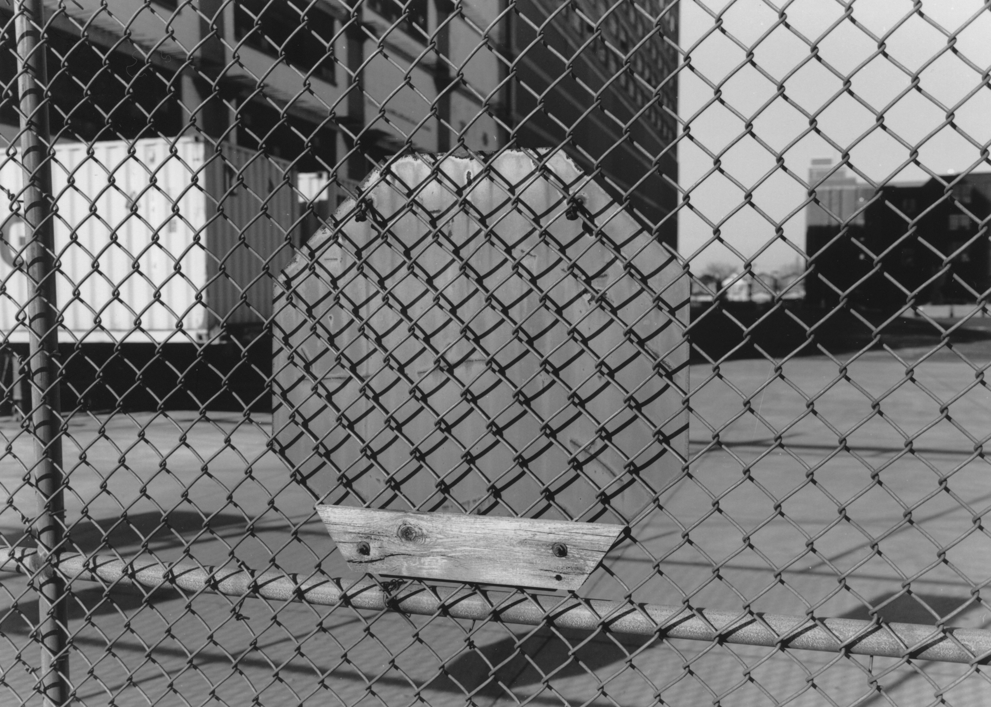 Rear of sign through fence with wood