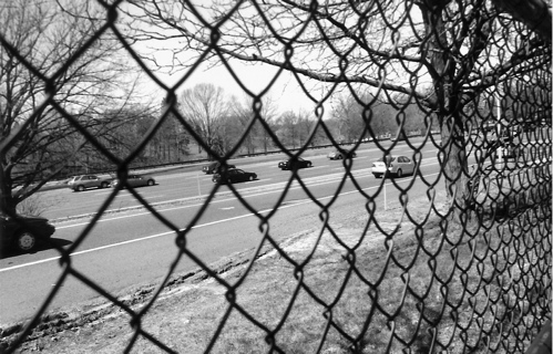 The NJ Garden State Parkway seen through a chain link fence