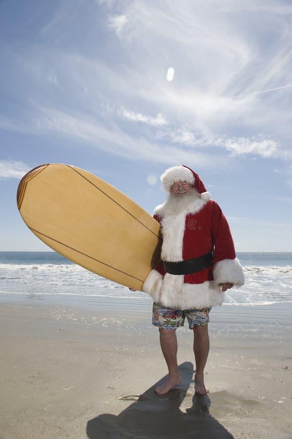 santa-claus-holding-surfboard-beach-29666140.jpg